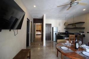 a kitchen and dining room with a table and a television at Calea Tulum in Tulum