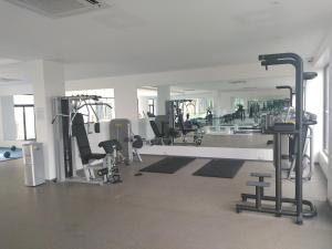 a gym with several treadmills and machines and a mirror at Embasy Gardens by Rosy Apartments in Accra