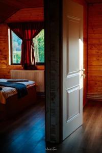 an open door to a bedroom with a bed and a window at CABANA EDEN in Cîmpeni +21 photos