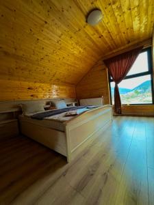 1 dormitorio con 1 cama en una habitación de madera con ventana en CABANA EDEN, en Câmpeni