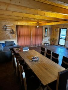 a dining room with a wooden table and chairs at CABANA EDEN in Cîmpeni