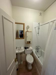 uma casa de banho com um WC, um lavatório e uma banheira em London Central Richmond Cozy Apartment em Richmond
