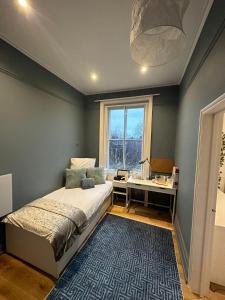a bedroom with a bed and a desk and a window at London Central Richmond Cozy Apartment in Richmond
