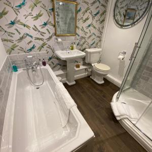 a bathroom with a tub and a sink and a toilet at Ashleigh Buxton in Buxton