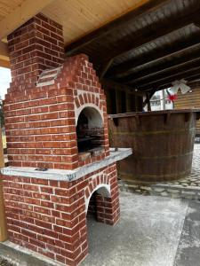 un horno de ladrillo al aire libre sentado bajo un techo en CABANA EDEN, en Câmpeni
