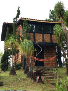 uma cabana com palmeiras em frente em Chalés Serra do Trovão em Lavras Novas