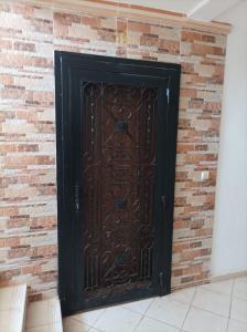 a large black door in a brick wall at Al fajar2 in Alimadene