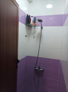 a bathroom with a shower with purple and white tiles at Al fajar2 in Alimadene