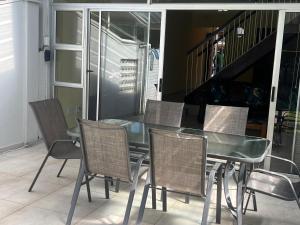 a dining room with a glass table and chairs at Ripplewood in Vereeniging