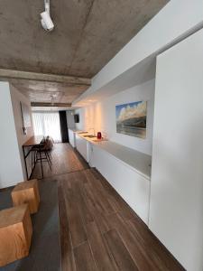 a living room with white walls and wooden floors at Departamentos en Gral Paz a pasos de clínicas in Cordoba