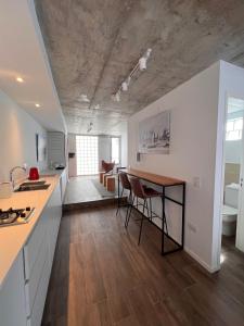 a kitchen and living room with a counter and a table at Departamentos en Gral Paz a pasos de clínicas in Cordoba