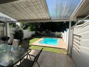 a patio with a table and a swimming pool at Ripplewood in Vereeniging