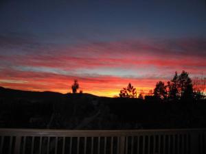 einen Sonnenuntergang mit einer Person auf einem Hügel in der Unterkunft Outrageous Lake View Villa pets ok in Lake Arrowhead