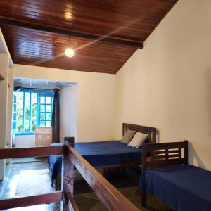 1 dormitorio con 2 camas y techo de madera en Casas MDP ilhabela/2, en Ilhabela
