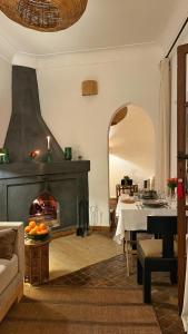 a living room with a fireplace and a table at Riad Dar Zaman in Marrakech