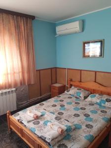 a bedroom with a bed with a blue wall at Къща за гости Жорж in Bankya