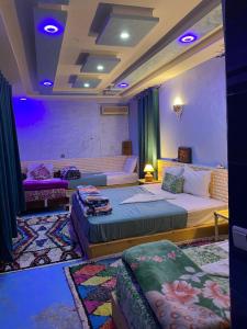 een hotelkamer met 2 bedden en een bank bij Salwa in Aït Ben Haddou