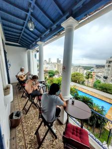 a group of people sitting at tables on a balcony at Rio World Connection Hostel in Rio de Janeiro