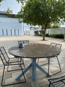 - une table avec deux chaises et un arbre sur la terrasse dans l'établissement White House Residences, à Lusaka