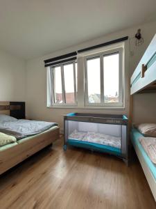 a bedroom with two beds and two windows at Kašperky in Kašperské Hory