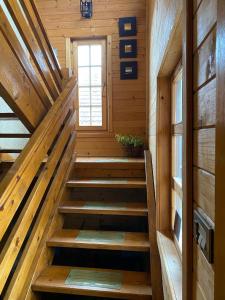 eine Treppe in einer Holzhütte mit einem Fenster in der Unterkunft Apartment Dea in Kolašin