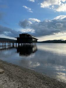 un muelle en el agua con una casa en él en Designový apartmán Molo Lipno, en Český Krumlov