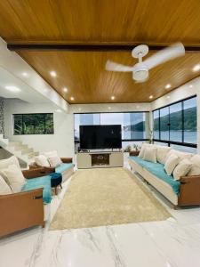 een woonkamer met banken en een flatscreen-tv bij Recanto Luxo Vista Mar in Angra dos Reis