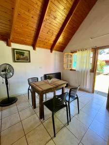 comedor con mesa de madera y sillas en Cabanas MERALE Excelente Ubicacion en Puerto Iguazú