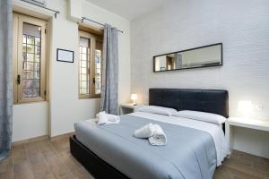 Schlafzimmer mit einem Bett und einem Wandspiegel in der Unterkunft Comfort Rooms Piazza Mariano Armellini in Rom