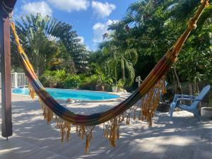 a hammock in front of a swimming pool at La VILLA DU GOLF in Les Trois-Îlets