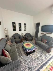 uma sala de estar com dois sofás e uma mesa em Appartement Chebbi em Tozeur