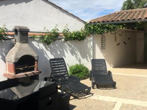 a patio with two chairs and an outdoor oven at La Petite Maison sur l'Ile de Ré in La Flotte