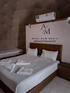 a bed in a room with a wall run maker sign at WADi RUM MAGIC CAMP in Wadi Rum
