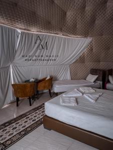 a tent with two beds and a desk in a room at WADi RUM MAGIC CAMP in Wadi Rum