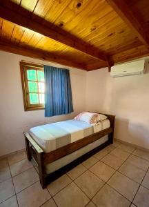 1 dormitorio con 1 cama en una habitación con ventana en Cabanas MERALE Excelente Ubicacion en Puerto Iguazú