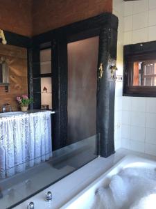 a bathroom with a bath tub with a window at Chalés Serra do Trovão in Lavras Novas