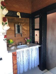 uma casa de banho com um lavatório e um espelho em Chalés Serra do Trovão em Lavras Novas