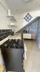 een keuken met een zwarte kookplaat in een kamer bij Recanto Luxo Vista Mar in Angra dos Reis