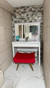 Recanto Luxo Vista Mar في انغرا دوس ريس: حمام مع مقاعد حمراء أمام مرآة