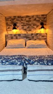 a bedroom with a bed with two pillows and two lights at Recanto Luxo Vista Mar in Angra dos Reis