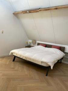a bed in a room with a ceiling at Villavento in Hoofddorp