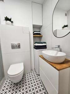 a white bathroom with a sink and a toilet at Apartament wakacyjny Brzeźno in Gdańsk