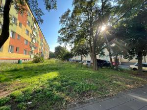 a grassy area next to a building with the sun shining at Apartament wakacyjny Brzeźno in Gdańsk