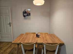 a wooden table with chairs in a room at Apartament wakacyjny Brzeźno in Gdańsk