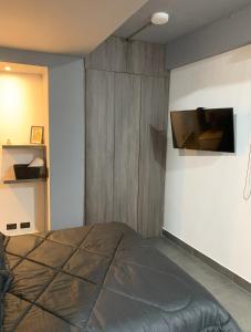 a bedroom with a bed and a tv on a wall at Apartamento Loft Bogotá in Bogotá