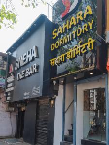 a restaurant with signs on the side of a building at Sahara Dormitory in Mumbai