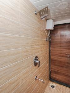 y baño con ducha y pared de madera. en Sahara Dormitory, en Bombay