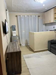 uma pequena sala de estar com uma mesa e uma cozinha em The comfort place Eldy em Eldoret