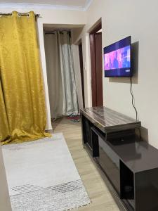 uma sala de estar com uma televisão de ecrã plano na parede em The comfort place Eldy em Eldoret