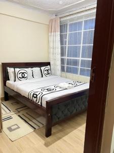 um quarto com uma cama em frente a uma janela em The comfort place Eldy em Eldoret